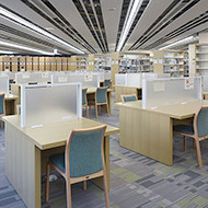 福島県立医科大学の図書館内、明るい照明の下に整然と配置された学習スペースと机。