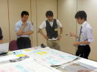 福島県立医科大学のサマーセミナーで、参加者が資料を見ながら議論している様子。