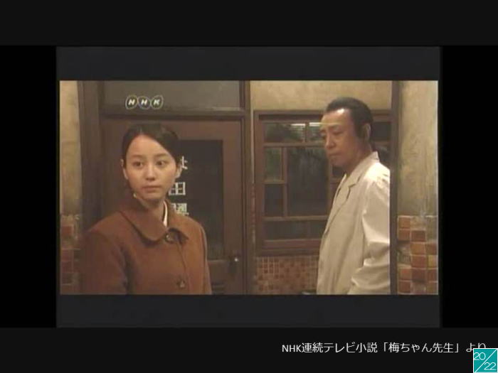 講演中の医師と聴衆の女性が対話しているシーン。背景には古い病院の内装が見える。