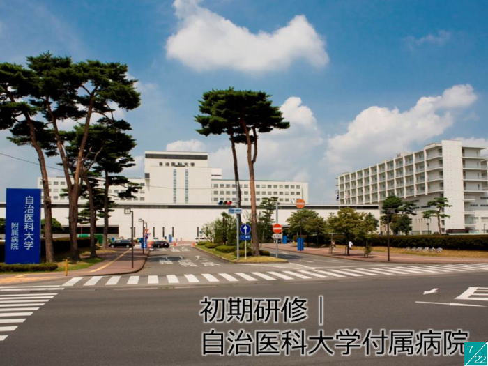 福島県立医科大学附属病院の外観と周囲の風景、青空の下に立つ建物が写っている。