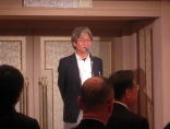福島県臨床研修病院ネットワークのイベントで講演する田勢長一郎氏。背景には装飾された壁が見える。