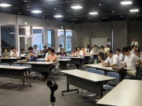 福島県立医科大学での学生災害ボランティア活動報告会の様子。多くの学生が集まり、真剣に話を聞いている。