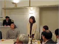 災害・放射線被ばく医療研修の懇親会でスピーチをする女性と参加者たち。