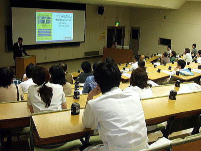 セミナーで講演を行う講師と、聴講する医療関係者たちの様子。
