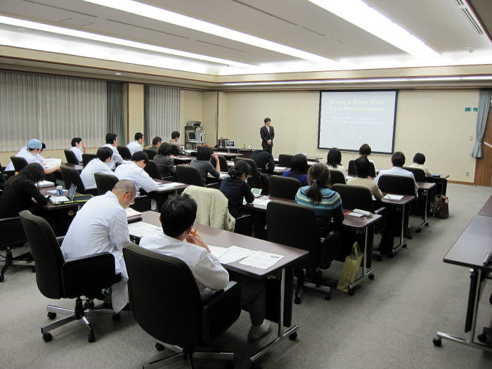 福島県立医科大学で行われたセミナーの様子。講師がプレゼンテーションを行い、参加者が聴講している。