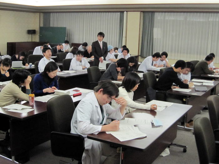 セミナーで真剣に学ぶ医療関係者たちが集まる教室の様子。