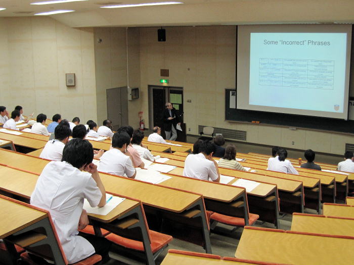 セミナーで講師がプレゼンテーションを行い、学生たちが熱心に聴講している様子。
