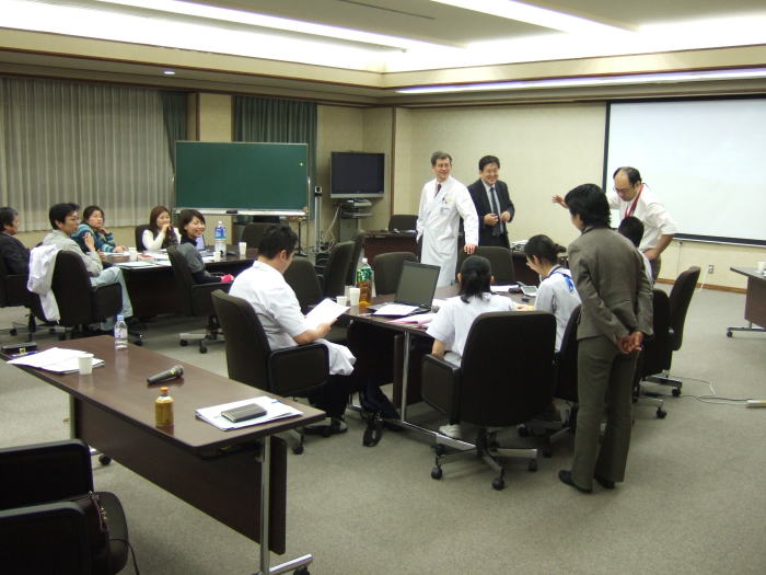 セミナーで議論を交わす医療関係者たちが集まる会議室の様子。