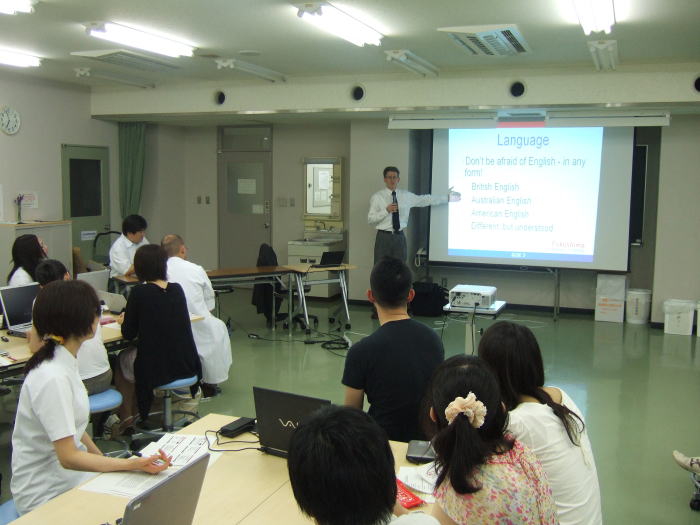セミナーで講演を行う講師と、参加者が座っている様子。スクリーンには「Language」と題されたスライドが映し出されている。