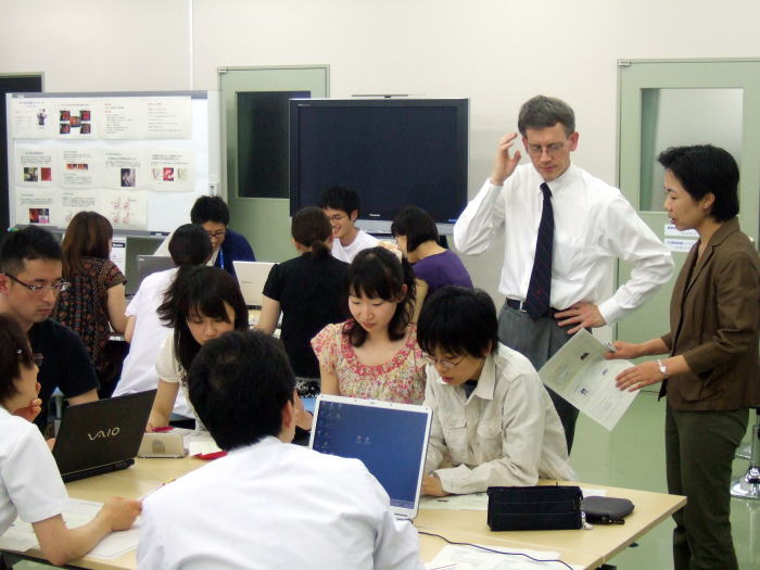 セミナーでディスカッションを行う参加者たちが、パソコンを使いながら意見を交わしている様子。