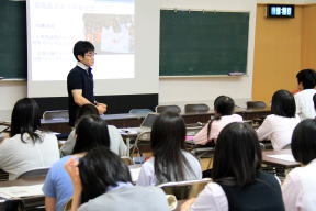 医大生がセミナーで活動内容を紹介している様子。教室内でのプレゼンテーション。