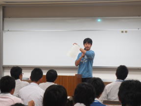 医大生が医療系セミナーのオリエンテーションで説明を行っている様子。受講生たちが真剣に聞いている。