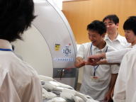 医療系セミナーで磁力の強さに驚く学生たちが、機器を指さしている様子。