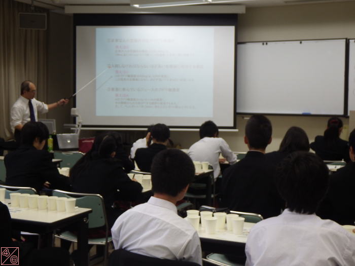 出前講座で講師がスライドを指し示し、学生たちが聴講している様子。