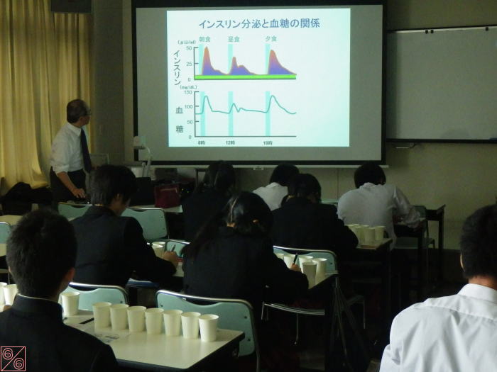 出前講座で講師がインスリンと血糖の関係について説明している様子。生徒たちは講義を受けながらメモを取っている。