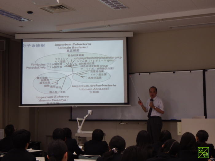 出前講座で講義を行う講師と、スライドを見つめる学生たちの様子。