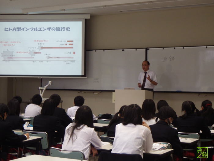 出前講座で講演する講師と、聴講する学生たちの様子。スライドにはヒトA型インフルエンザの情報が表示されている。