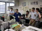 WEB会議システムを見学する福島県立医科大学の職員と訪問者たちが、オフィス内で説明を受けている様子。