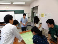 学生たちがテーブルを囲み、意見を出し合いながら学習している様子。