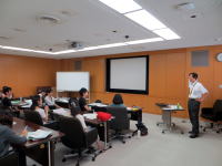 医療に関する講義を受ける学生たちと講師がいる教室の様子。