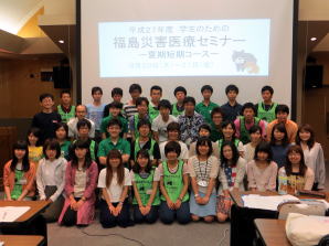 福島県立医科大学のセミナーに参加する学生たちが集合している写真。緑のTシャツを着た参加者が目立つ。