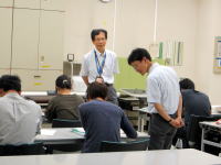 福島県立医科大学の教室で、講師が学生に指導している様子。学生たちは机に向かって学習中。