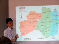 福島県の地図を背景に、講義を行う男性の姿。