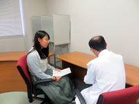 医師と患者が相談している様子。患者は真剣な表情で話を聞いている。