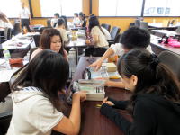 学生たちがテーブルを囲んで、資料を見ながら話し合っている様子。