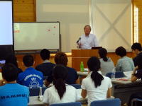 福島県立医科大学での講義中の様子。講師が前で話し、学生たちが熱心に聴講している。