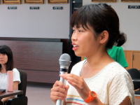 福島県立医科大学の講義中に発言する女性と、後方に座る学生たちの様子。
