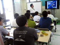 災害医療に関する講義を受ける学生たちと講師が映る教室の風景。