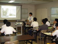 福島県立医科大学の教室で、講師がプレゼンテーションを行い、学生たちが聴講している様子。