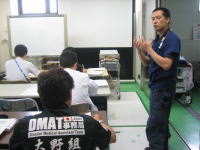 救急外傷処置の講義を受ける医療従事者たちと、指導する講師の様子。