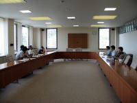 福島県立医科大学の会議室で、参加者がテーブルを囲んで話し合っている様子。
