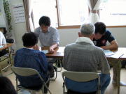 医療に関する活動を行う人々が集まり、テーブルを囲んで話し合っている様子。