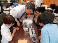 医療機器を囲んで話し合う福島県立医科大学の学生と教員の様子。