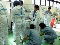 医療用防護服を着用する医学生たちが、実習室で準備を進めている様子。