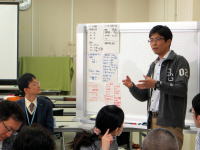 福島県立医科大学の講義中、発表を行う男性と聴講する学生たちの様子。