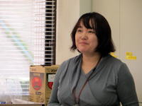 臨床心理士が話している様子、背景には窓と箱が見える。福島における避難者の心理的支援に関する講演中。