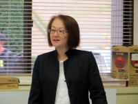 福島県立医科大学で講演を行う女性の姿。窓からの光が差し込む室内で、真剣な表情で話している。