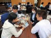 医療に関するディスカッションを行う福島県立医科大学の学生たち。テーブルには医療機器や資料が並んでいる。