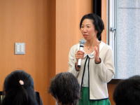 福島県立医科大学で講演を行う女性が、聴衆に向けて話している様子。