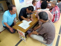 地域の健康相談会で、医療スタッフが高齢者にアドバイスを行っている様子。