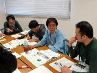 福島県立医科大学での会議中の様子。数人の男性がテーブルを囲み、資料を見ながら話し合っている。