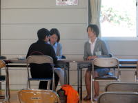福島県立医科大学の教室で、学生がテーブルを囲んで話し合っている様子。