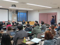 大学の講義室で行われた総合討論の様子。パネリストが質問に答え、受講者が熱心に聴講している。