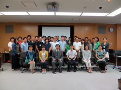 福島県立医科大学の会議室でのグループ写真、参加者が笑顔でポーズをとっている。
