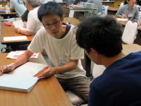 学生がテーブルを囲んで話し合い、資料を見ながら意見を交わしている様子。