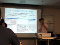 講義中の講師がスライドを指し示し、受講生が聴講している様子。スライドには急性放射性症候群に関する情報が表示されている。